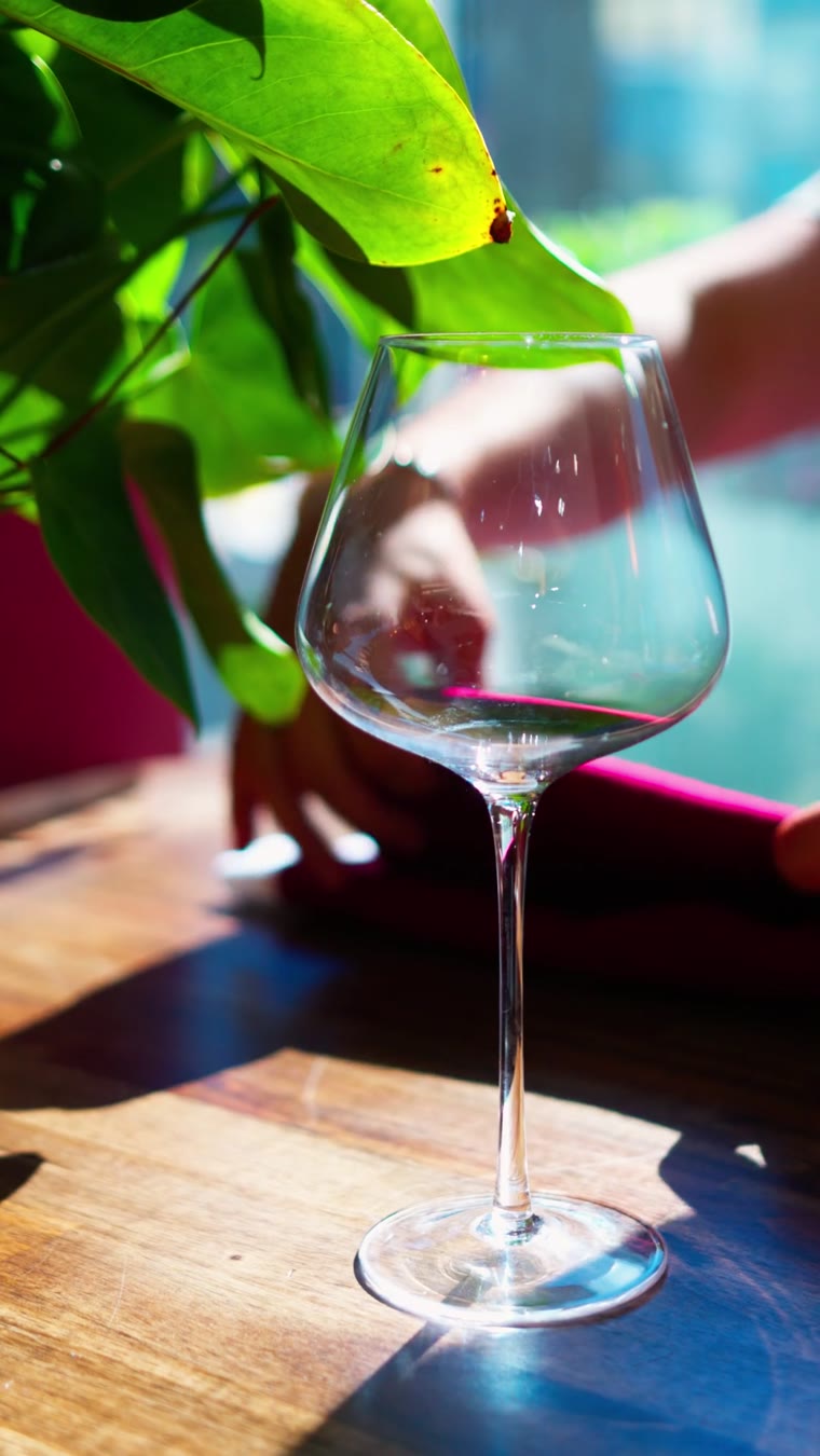Cheminé, red wine poured into a glass on a pink tablecloth