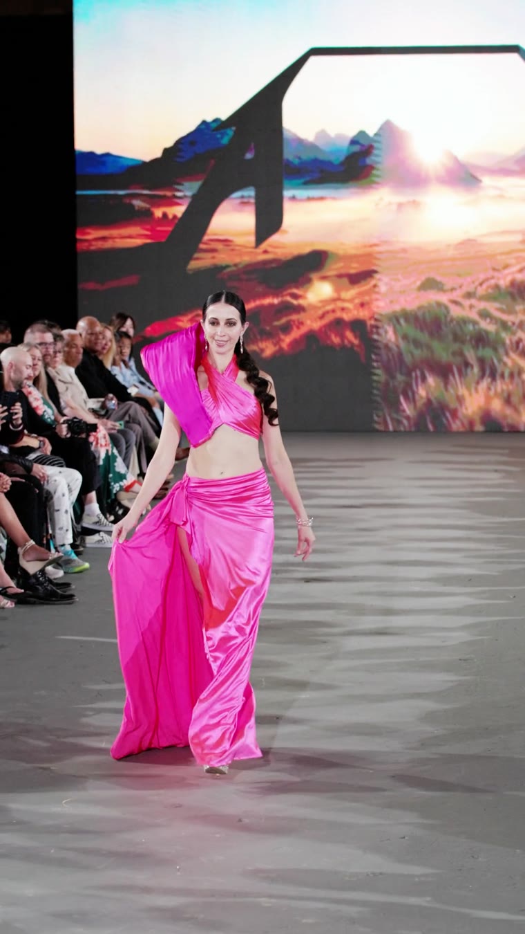 A model in a pink satin gown walking the runway