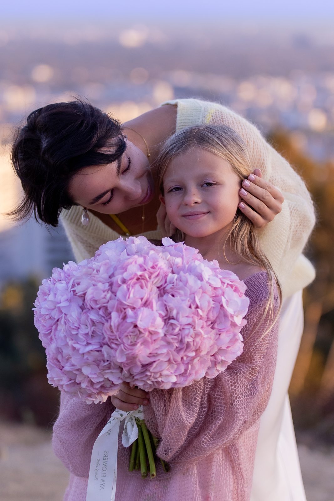 Mother Nobelle collection, mother holding her daughter with pink hydrangeas